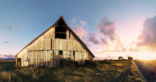 Puesta de sol en un granero abandonado, imagen en color
 - Foto, imagen