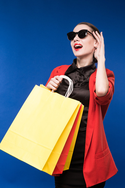 portrait of brunette girl in sunglasses with bags in the hands - Photo, Image