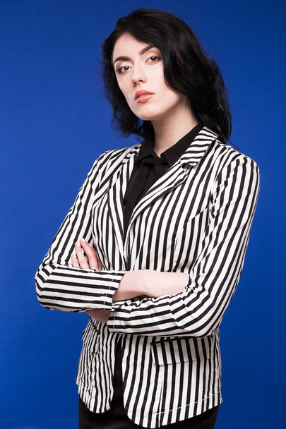 girl with black hair on a blue background - Fotoğraf, Görsel