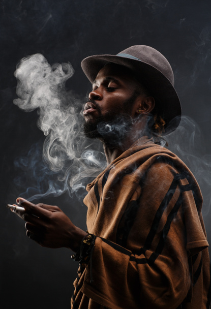 man in hat roken - Foto, afbeelding