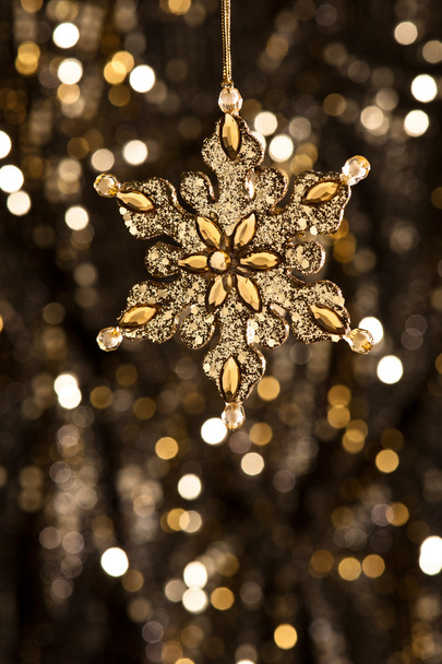 Floco de neve artificial em ouro
 - Foto, Imagem