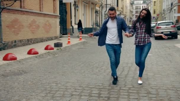 Lento tiro em movimento de jovem casal dançando ao longo da rua em direção à câmera
. - Filmagem, Vídeo