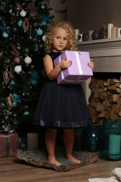 Little girl stands with a gift on the pillow - Photo, image