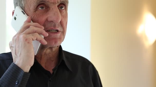 Hombre mayor con teléfono inteligente blanco habla
 - Imágenes, Vídeo