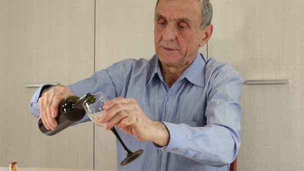 Szürke hajú idősebb ember iszik bor - Felvétel, videó