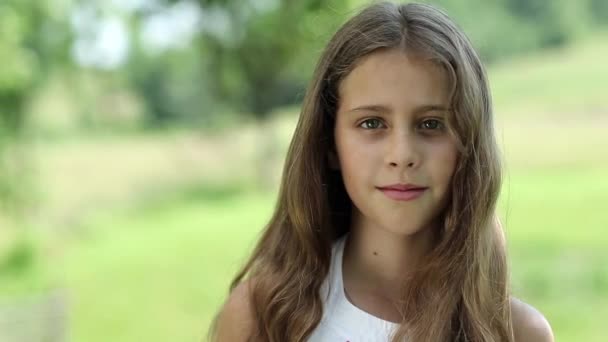 hübsches Mädchen mit langen Haaren schaut in die Kamera - Filmmaterial, Video