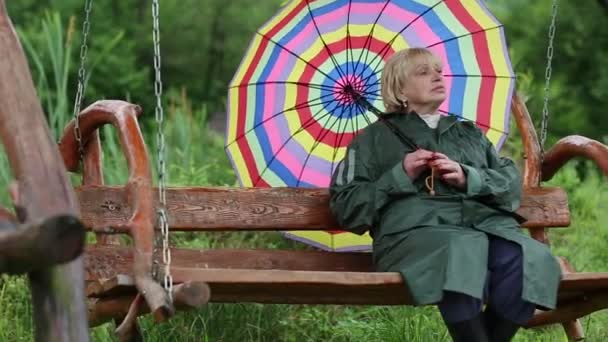 Mujer en impermeable verde y con paraguas
  - Metraje, vídeo