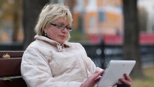 Starší blondýna žena s tablet pc - Záběry, video