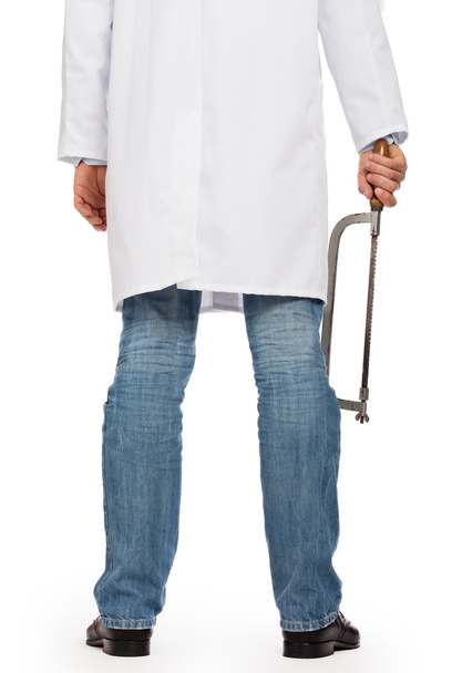 Médico louco está segurando uma serra grande nas mãos
 - Foto, Imagem