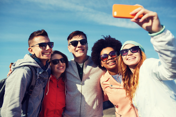 smiling friends taking selfie with smartphone - Fotó, kép