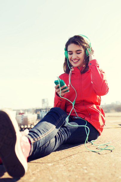 glückliche junge Frau mit Smartphone und Kopfhörer - Foto, Bild