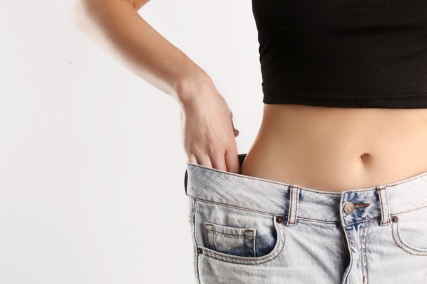 Fit feminino vestindo jeans grandes após a dieta
 - Foto, Imagem