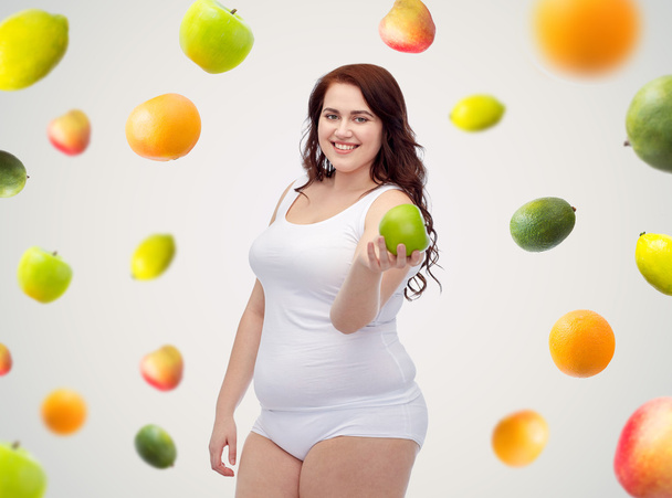 happy plus size woman in underwear with apple - Фото, изображение