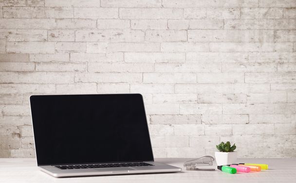 Business laptop with white brick wall - Foto, imagen