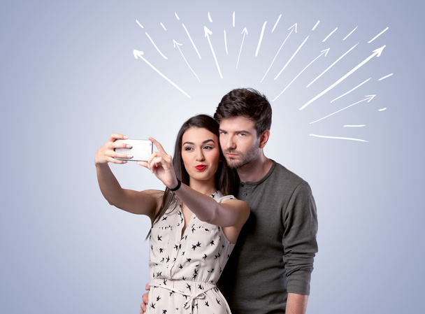 Cute couple taking selfie with arrows - Фото, изображение
