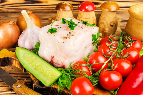 Stück frisches Schweineschmalz, frische Produkte, Gemüse auf dem Holzbrett und Messer auf dem Tisch, Nahaufnahme - Foto, Bild