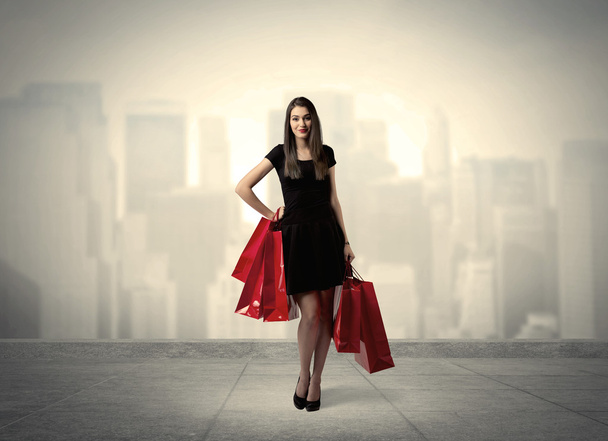 Elegant city girl with red shopping bags - Fotoğraf, Görsel
