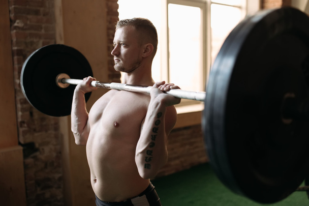 Strong man lifting barbell  - Foto, afbeelding