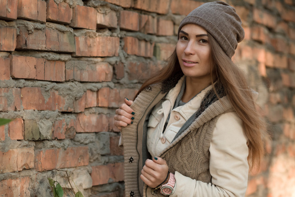 Beautiful woman posing over brick wall - Foto, afbeelding