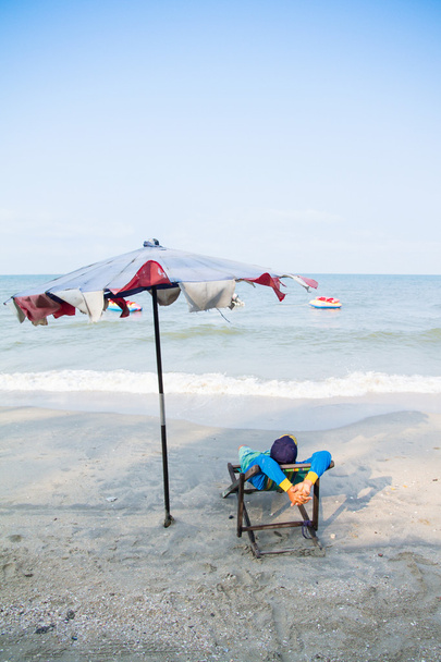 Hombre en sillas de playa por la mañana junto al mar, Concepto en el be
 - Foto, imagen