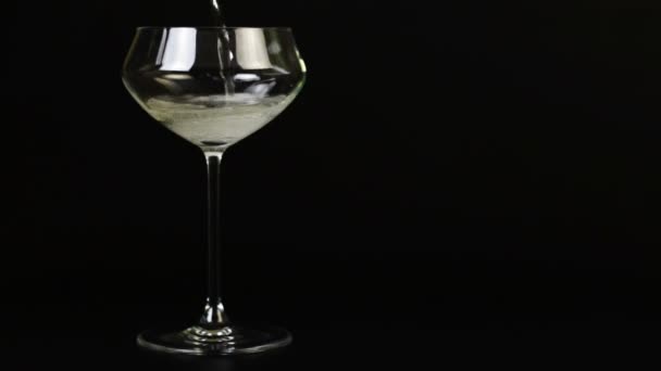 Pezsgőt öntenek egy pohár a fekete háttér - Felvétel, videó