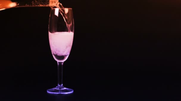El champán se vierte en una copa sobre un fondo negro
 - Metraje, vídeo