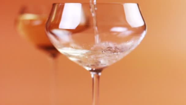 Champagne is poured into a glass on a cream background - Footage, Video