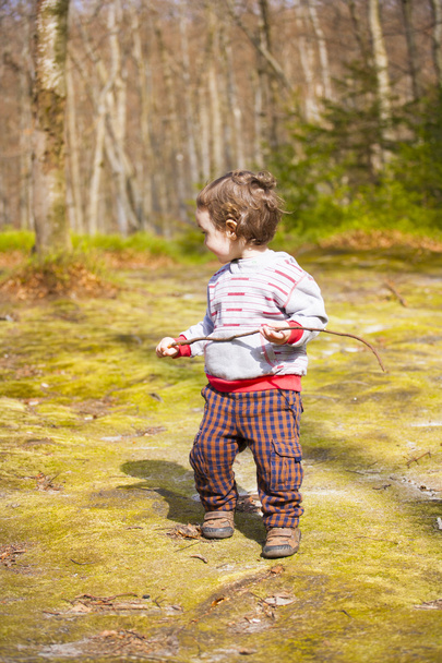 A little boy playing in the woods. - Zdjęcie, obraz