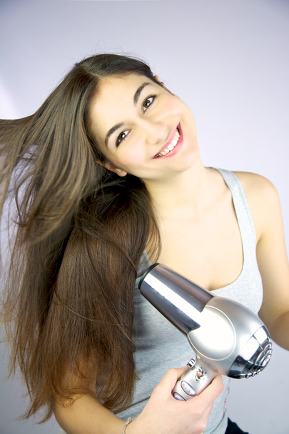 Щаслива дівчина сушить довге волосся
 - Фото, зображення