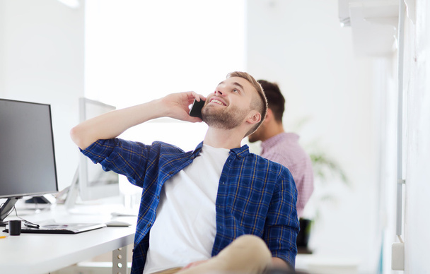 happy creative man calling on cellphone at office - Photo, image