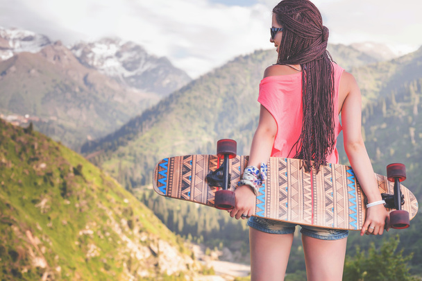 Fashion teenage girl with longboard skateboard at mountain - Φωτογραφία, εικόνα