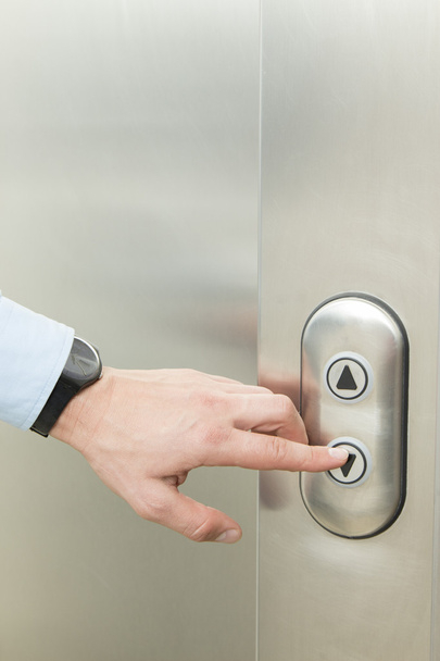 Pushing elevator down button - Фото, зображення