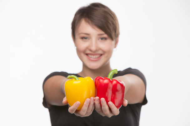 Photos of a beautiful girl with yellow and red pepper - Foto, Imagen