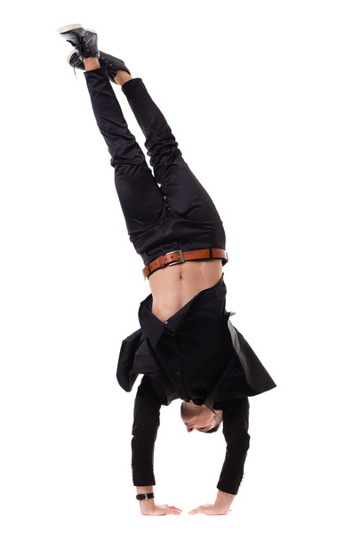 One fit handsome modern style dancer young man working out, performing breakdance moves, hand stand on the floor. - Photo, Image