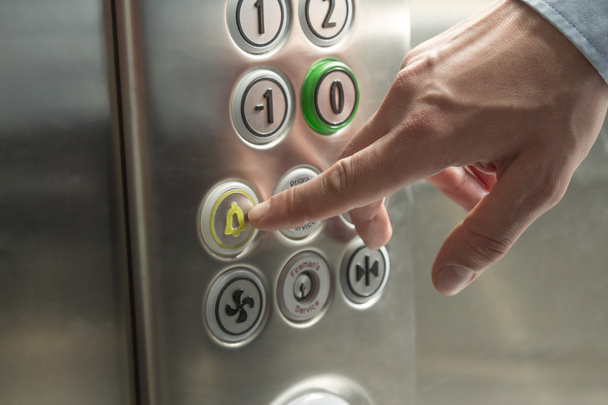 Hand pressing the alarm button in the elevator - Foto, Imagen