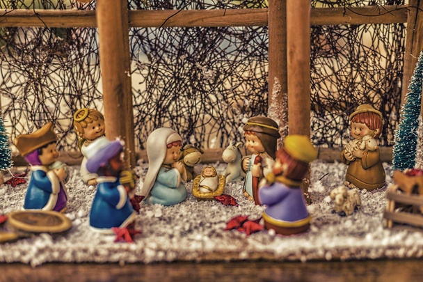 Joulun synttärikohtauksen kirkkaat värit, siunattu Neitsyt Maria ja Pyhä Joosef vartioivat pyhää lasta Jeesusta seimessä härän ja aasin lämmetessä ja samalla kun kolme viisasta miestä kantaa lahjoja
 - Valokuva, kuva