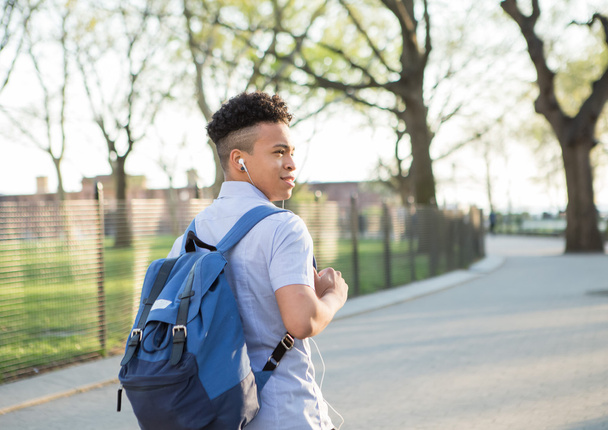 Jovem menino hispânico com pacote de caminhada no campus da faculdade
 - Foto, Imagem