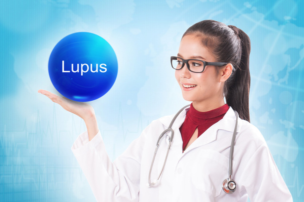 Ärztin mit blauer Kristallkugel mit Lupus-Zeichen auf medizinischem Hintergrund. - Foto, Bild