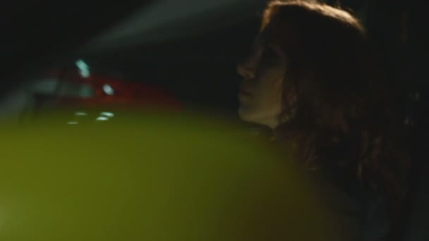 Brunette wait calm with hand on the steering wheel hiding face in shadow in car - Filmagem, Vídeo