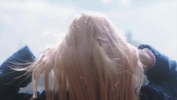 Όμορφο κορίτσι με τα ξανθά μαλλιά από behinde. αργή κίνηση - Πλάνα, βίντεο