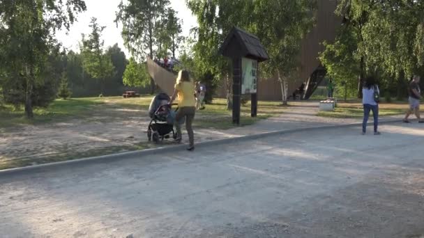 Mutter fährt mit Kinderwagen. modernes Gebäude in der Natur. 4k - Filmmaterial, Video