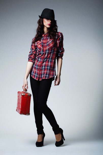 Beautiful brunette girl with red suitcase - Фото, изображение