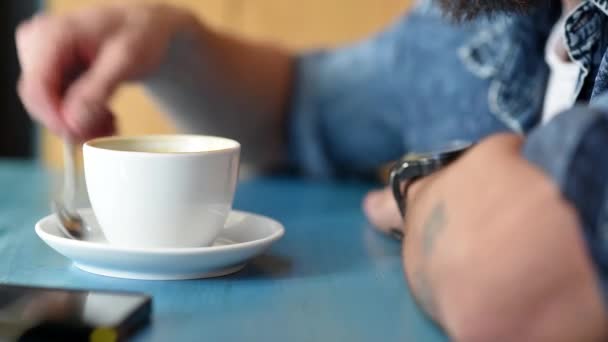Close up of young man drinking coffee at the coffee shop - Materiaali, video
