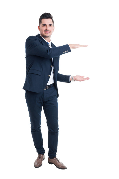 Smiling salesman holding copy space with hands - Photo, image