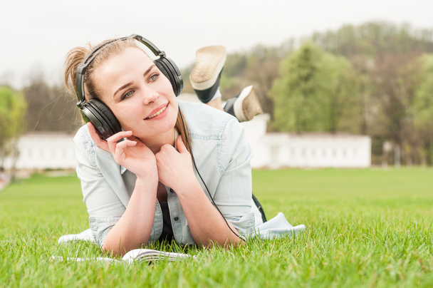 Young happy girl with headphones listening music  - Fotó, kép