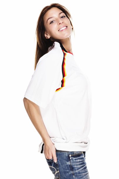 Happy beautiful woman wearing football shirt with hand in her back pocket - 写真・画像