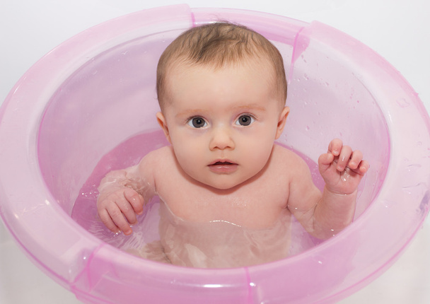Μικρό μωρό κάνει μπάνιο στην μπανιέρα ροζ - Φωτογραφία, εικόνα