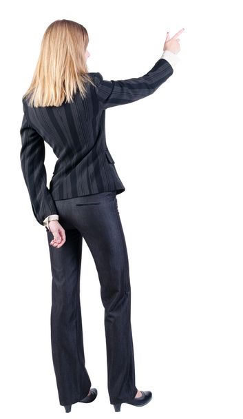 Back view of young blonde business woman pointing at wal - Foto, Bild