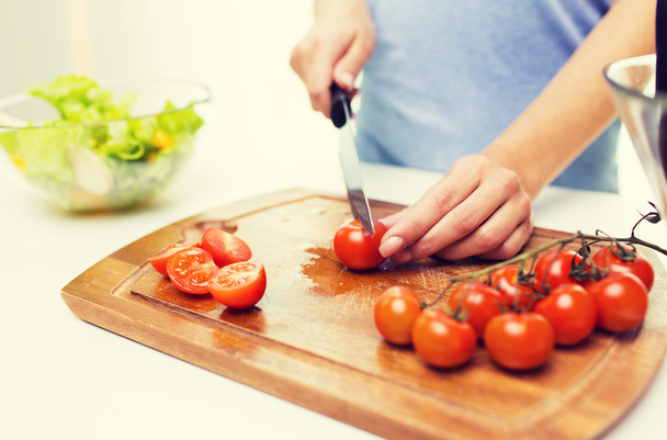 close up of woman chopping tomatoes with knife - Foto, imagen