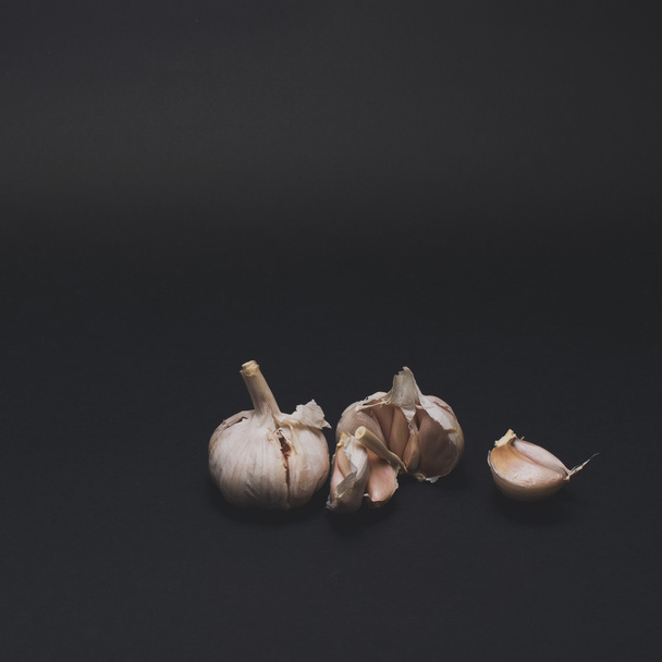 garlic on black table - Фото, изображение